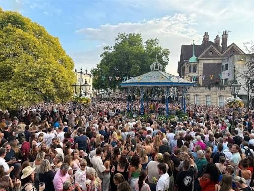 A huge crowd around the bandstand on a summer evening